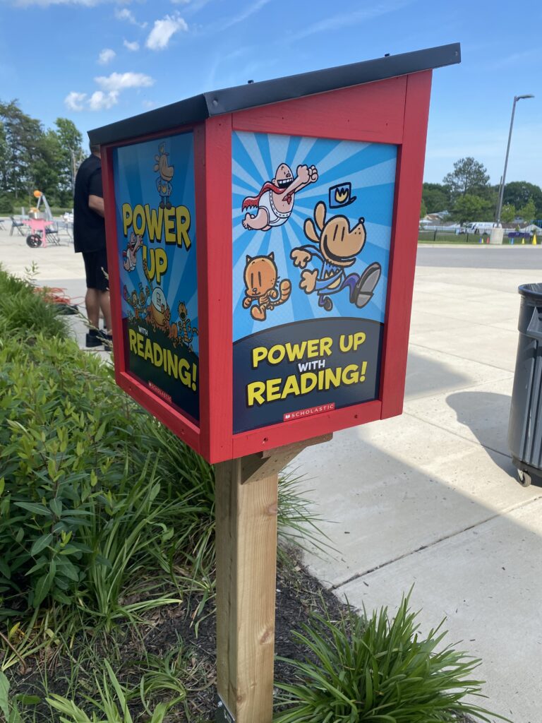 Boy taking books from little library