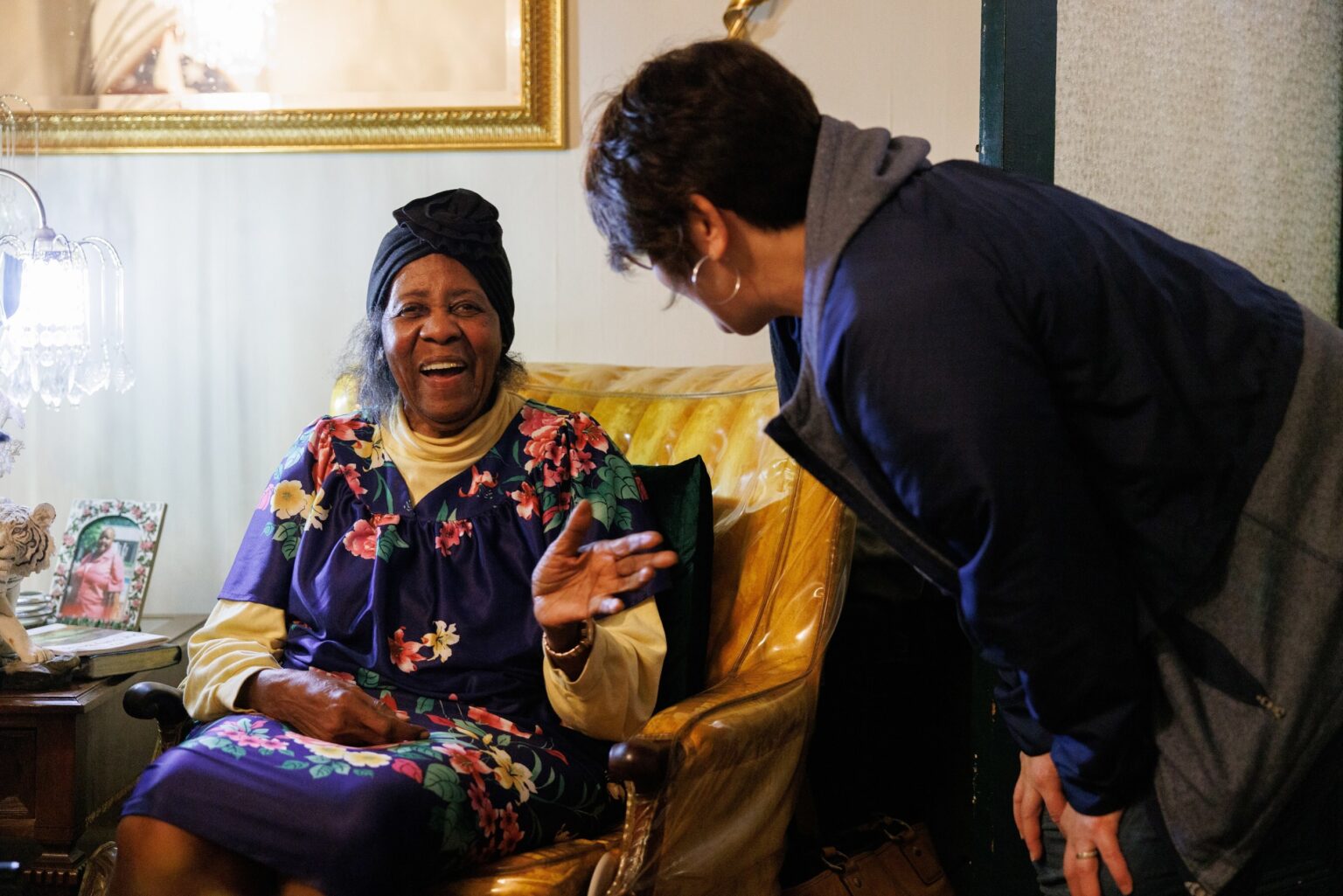 A man speaks with an elderly woman in this promotional image