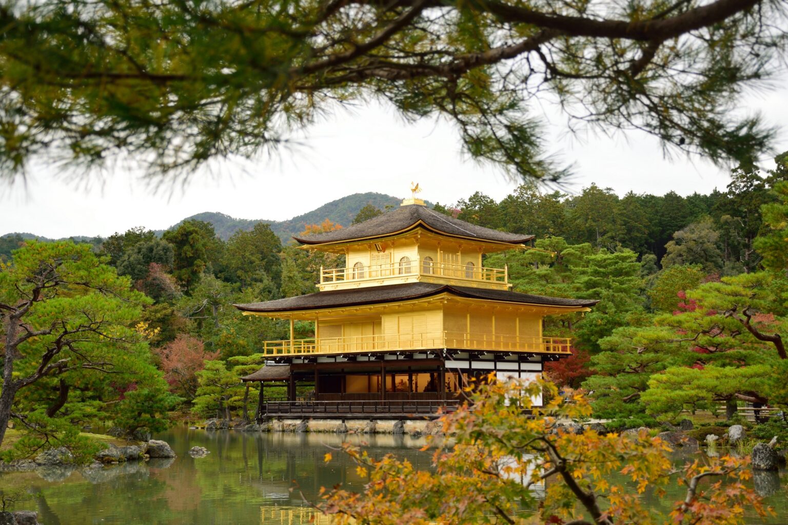 A vibrant temple in Kyoto, Japan is seen in front of lush greenery