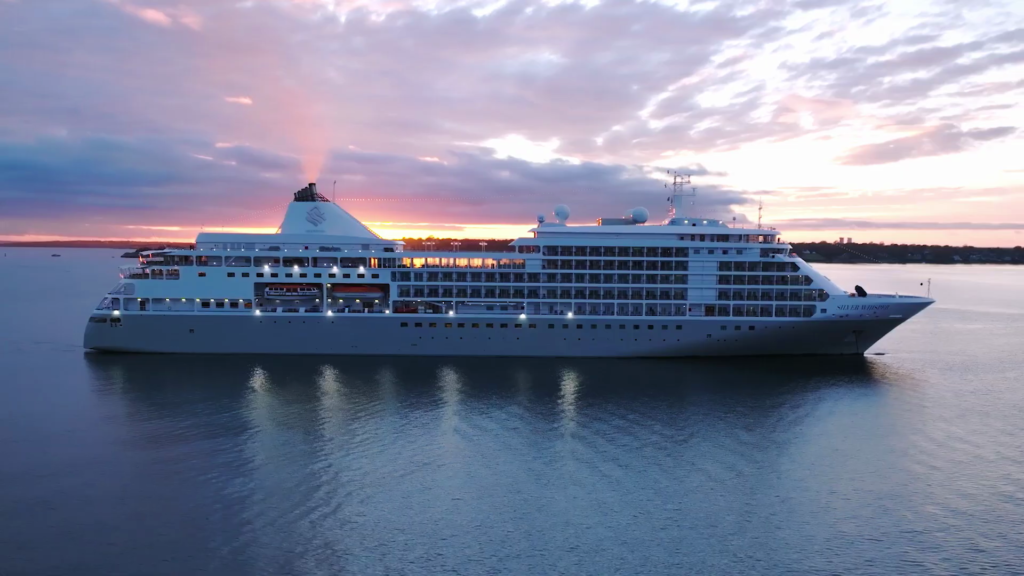 A Silversea cruise ship is seen floating in the water at sunset