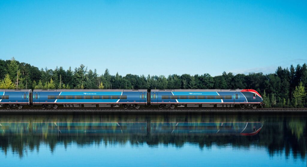 Rendering of an Amtrak Airo coach cab car traveling along a body of water with an open blue sky behind it. (Amtrak)