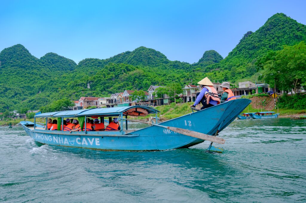 Travelers ride in a boat in the Phong Nha, Vietnam region in this photo from Pexels.com; Phong Nha was named one of Agoda's top Asian nature retreats for 2026