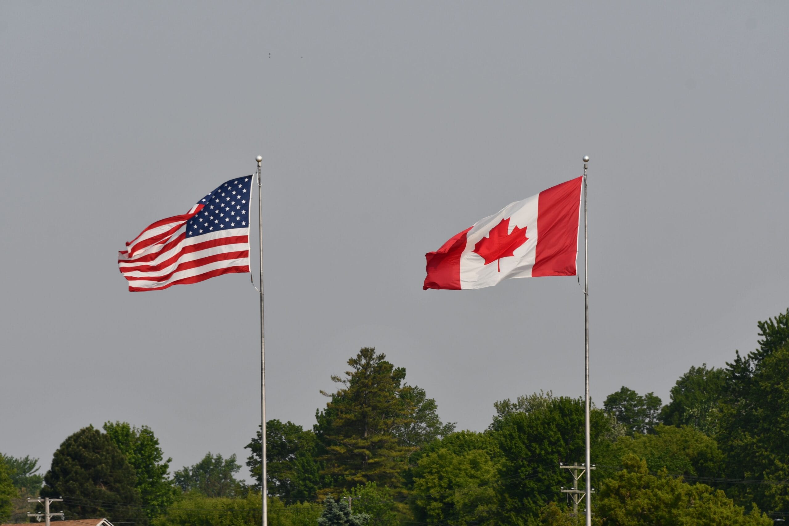 USA and Canada flags fly near a border crossing in Ontario, Canada. (Pexels.com) Canadian tourism continues to struggle in the U.S. since 2024.