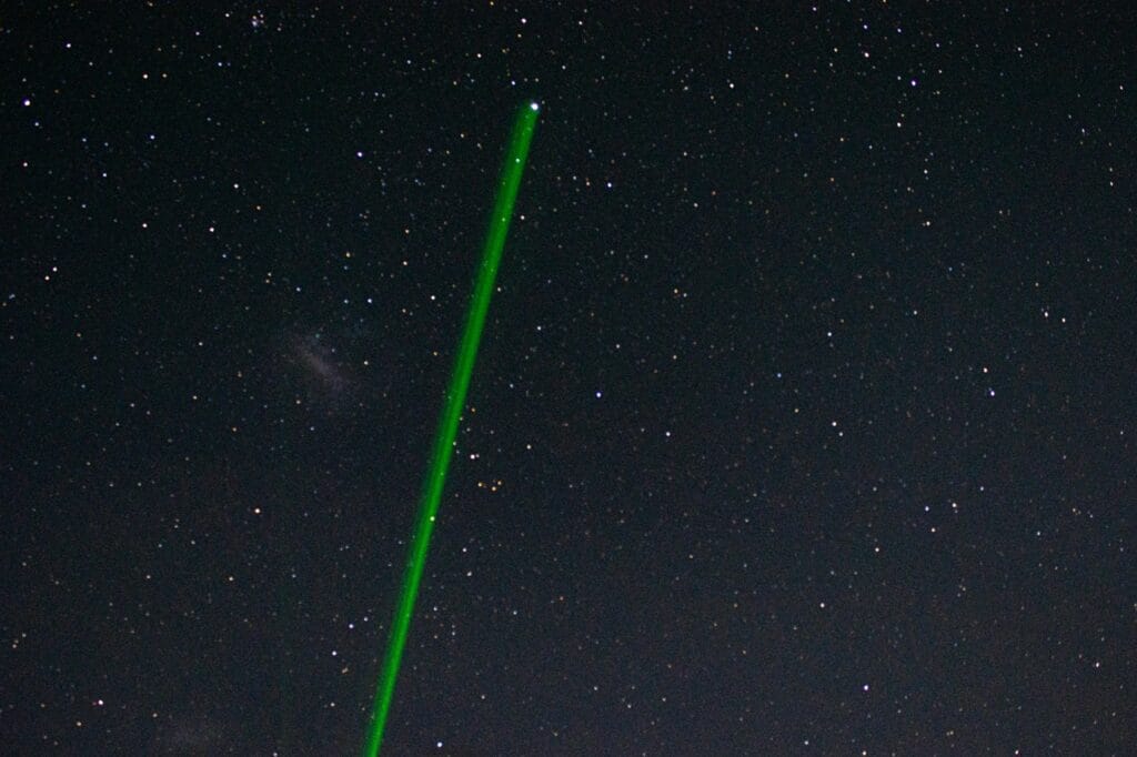 This stock image shows a beam of green light from a laser pointer pointed at the sky. (Unsplash.com)