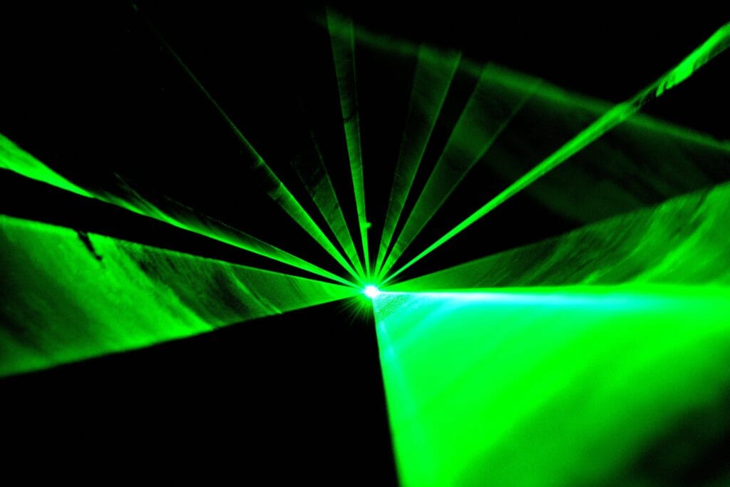 This stock image shows a beam of green light pointed at the lens of a camera. (Unsplash.com)