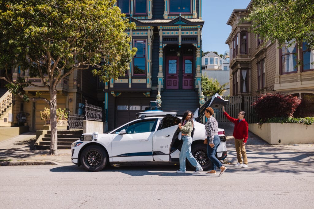 Riders are seen getting into a driverless taxi in this promotional image from Waymo.