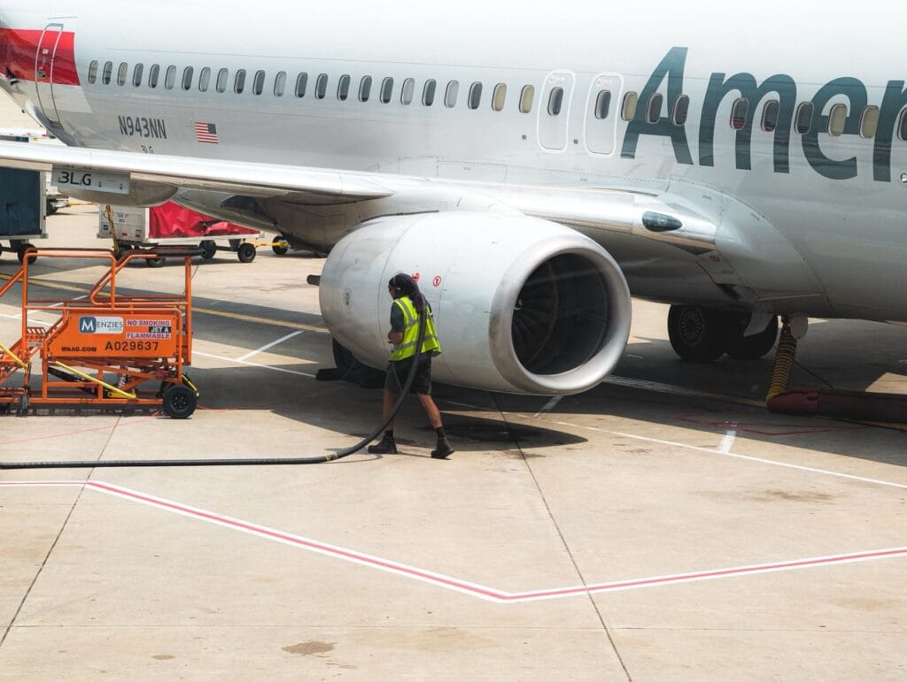 A worker services an American Airlines jet at the runway of the Harry Reid International Airport in this August 2026 image from Matthew Jackson/Pexels.com; Fuel prices have soared since the U.S. war with Iran.